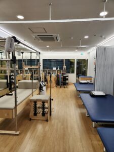 성남 분당 정자동에 위치한 라룬리픽스 재활운동센터의 운동실 이미지입니다. 필라테스장비, 허리 근육 이완에 도움이 되는 운동기구, 유연성이 부족한 분들의 스트레칭을 돕기 위한 높낮이 조절이 가능한 매트 등 다양한 장비가 있습니다. 바닥에는 겨울철 온열이 되는 마루바닥이고. 벽은 흰색으로 칠해져 있고, 창문이 있어 채광이 좋습니다.